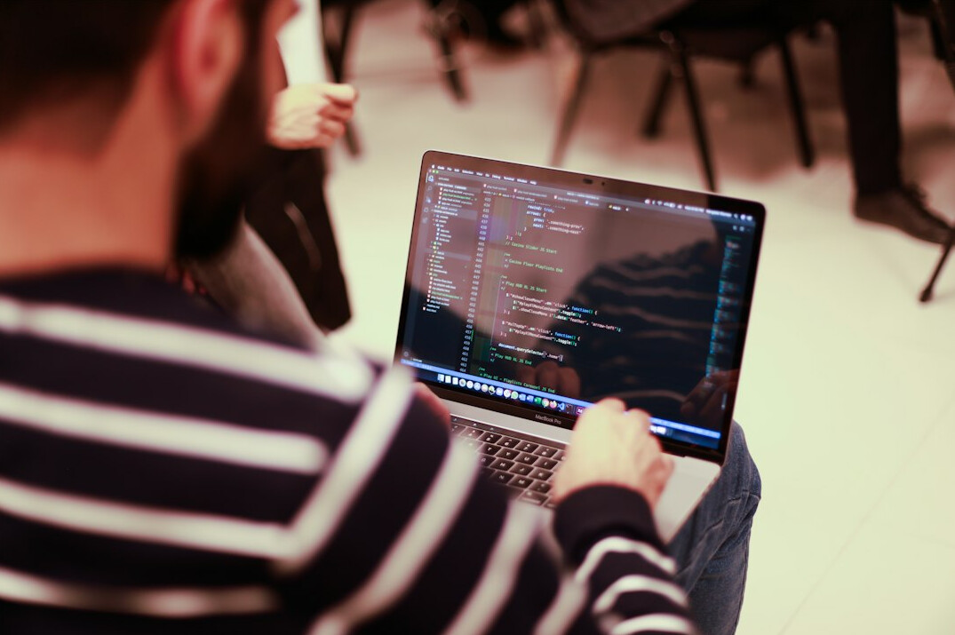 programmer coding on laptop